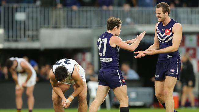 South Aussie export Lachie Neale and Michael Apeness celebrate Fremantle’s thrilling victory against and Adelaide at Perth’s Optus Stadium as the Crows players are left to rue what might have been. Picture: Paul Kane/Getty Images