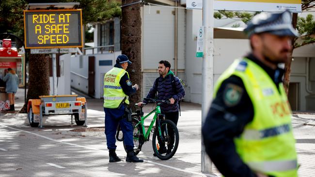 Police Highway Patrol officers stopped e-bike riders on Manly Beach on Wednesday to advise, and warn, them of their responsibilities to comply with NSW laws and condition as part of efforts to improve pedestrian and road safety. Picture: NCA NewsWire / Nikki Short