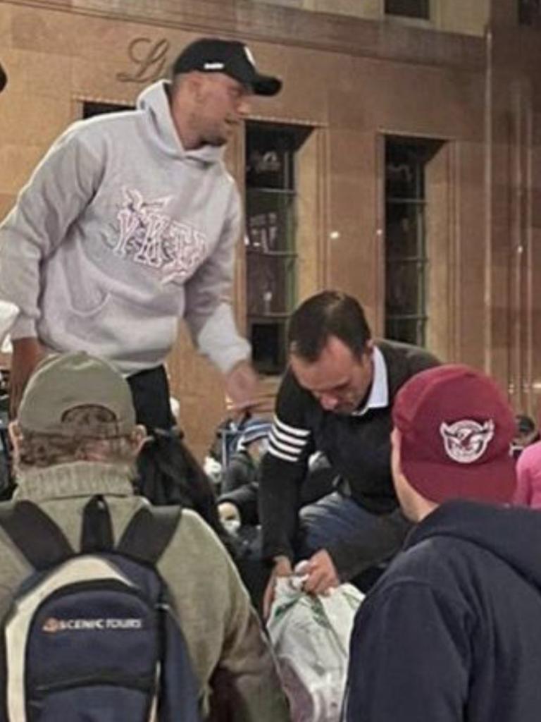 Cronulla Sharks’ Will Chambers and Dragons’ Corey Norman handing out clothes and meeting homeless people at Martin Place.