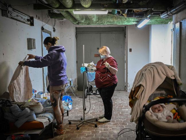 A nurse checks a baby being treated at a pediatrics center after unit was moved to the basement of the hospital which is being used as a bomb shelter, in Kyiv on February 28, 2022. - The Russian army said on February 28, 2022, that Ukrainian civilians could "freely" leave the country's capital Kyiv and claimed its airforce dominated Ukraine's skies as its invasion entered a fifth day. (Photo by Aris Messinis / AFP)