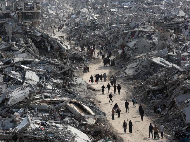 TOPSHOT - This aerial view shows displaced Palestinians returning to the war-devastated Jabalia refugee camp in the northern Gaza Strip on January 19, 2025, shortly before a ceasefire deal in the war between Israel and the Palestinian militant group Hamas was implemented. Mediator Qatar on June 19 confirmed the start of a truce between Israel and Hamas and said some of the initial three hostages to be freed hold foreign citizenship. (Photo by Omar AL-QATTAA / AFP)