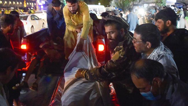 Volunteers and medical staff unload bodies from a truck outside a hospital after two powerful explosions rocked Kabul. Picture: AFP