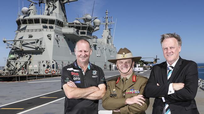  Port Adelaide coach Ken Hinkley with Major General Matthew Hall and Port chief Keith Thomas on the HMAS Adelaide on Friday. Picture: Sarah Reed