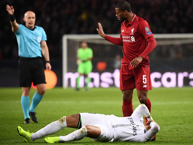 Paris Saint-Germain's Brazilian forward Neymar (C) reacts on the football pitch after vying for the ball with Liverpool's Dutch midfielder Georginio Wijnaldum (R) next to Polish referee Szymon Marciniak (L) during the UEFA Champions League Group C football match between Paris Saint-Germain (PSG) and Liverpool FC at the Parc des Princes stadium, in Paris, on November 28, 2018. (Photo by FRANCK FIFE / AFP)