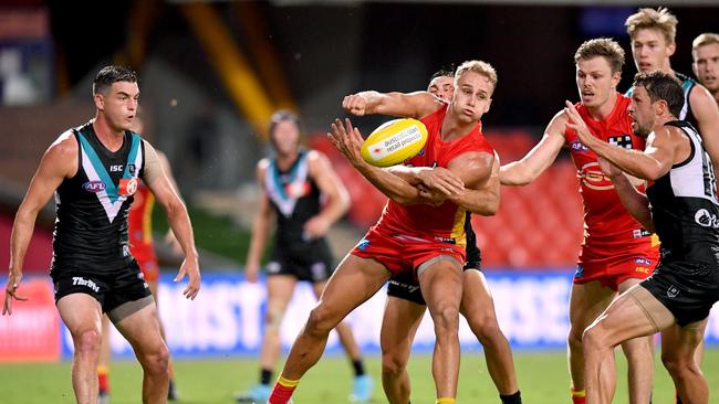 Will Brodie (centre) of the Suns in action during the Round 1 AFL match between the Gold Coast Suns and Port Adelaide Power at Metricon Stadium. (AAP Image/Darren England)