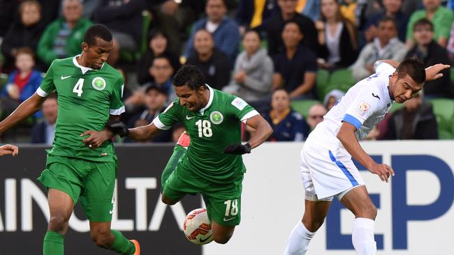 Abdulla Aldossary looks on as Salem Aldawsari is tackled by Anzur Ismailov of Uzbekistan.