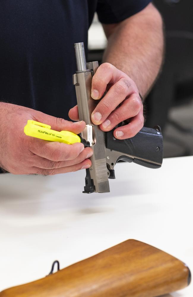 AFP experts process a gun found during the raids. Picture: NCA NewsWire / Martin Ollman