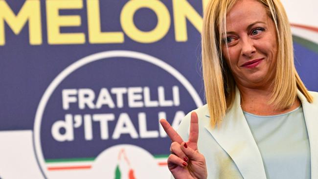 TOPSHOT - Leader of Italian far-right party "Fratelli d'Italia" (Brothers of Italy), Giorgia Meloni flashes a victory sign as she acknowledges the audience after she delivered an address at her party's campaign headquarters overnight on September 26, 2022 in Rome, after the country voted in a legislative election. - Far-right leader Giorgia Meloni won big in Italian elections on September 25, the first projections suggested, putting her eurosceptic populists on course to take power at the heart of Europe. (Photo by Andreas SOLARO / AFP)