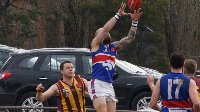 Wandin’s Justin Myers flies for the ball, ahead of Monbulk’s Michael Langworthy. Picture: Robyn Kuys