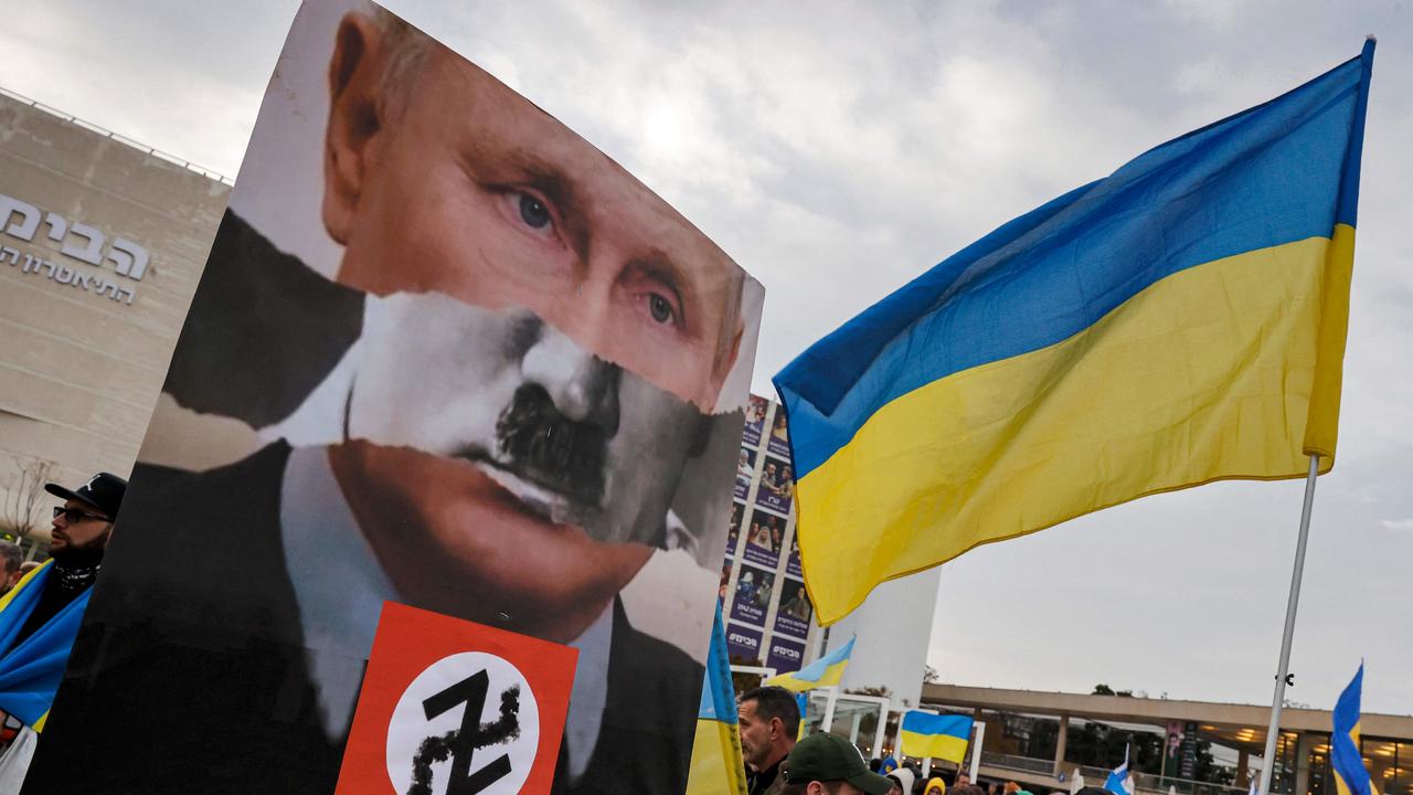 A demonstrator holds up a sign depicting the superimposed face of Russian president Vladimir Putin during a protest against Russia’s invasion of Ukraine. Picture: AFP