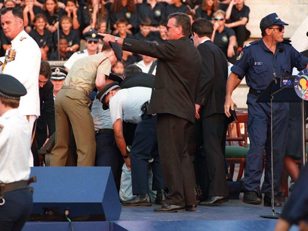 A gunman who fired a starting pistol at Prince Charles is held down by security guards.