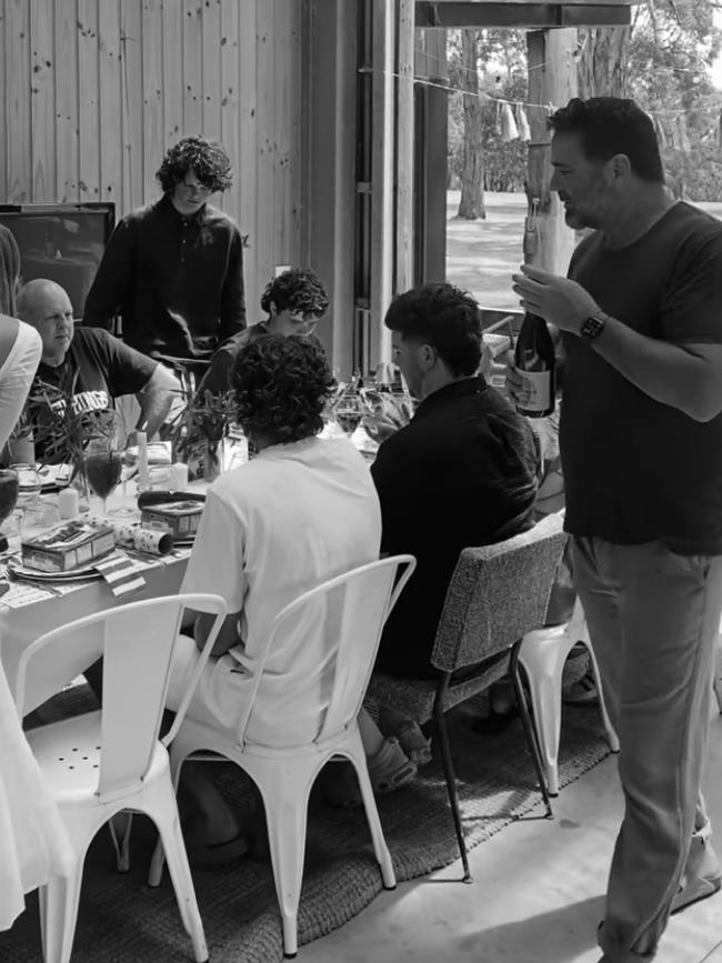 Garry Lyon brings wine to the table for Christmas lunch at his Red Hill property as Billy Brownless looks on.