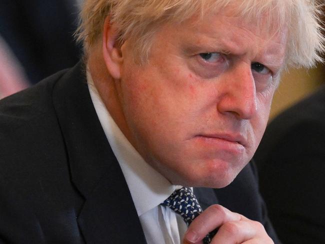 (FILES) In this file photo taken on May 24, 2022 Britain's then prime minister Boris Johnson adjusts his tie at the start of a cabinet meeting at 10 Downing Street in London. Johnson announced his resignation as an MP on June 9, 2023, accusing a parliamentary probe into the 