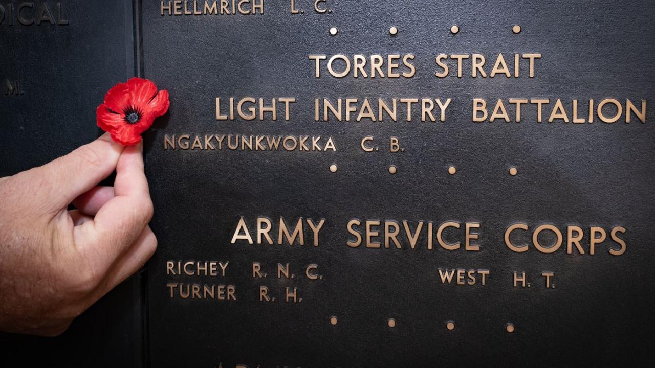 Australian War Memorial Indigenous liaison officer Michael Bell places a poppy beside the name of Private Ngakyunkwokka on the Roll of Honour. Picture: Supplied / Australian War Memorial