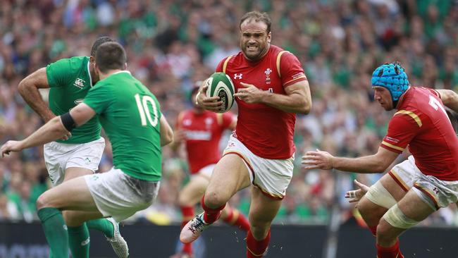 Wales Jamie Roberts, centre, side steps a tackle by Ireland's Johnny Sexton, left, during their international rugby union match at the Aviva stadium, Dublin, Ireland, Saturday, Aug. 29, 2015. (AP Photo/Peter Morrison)