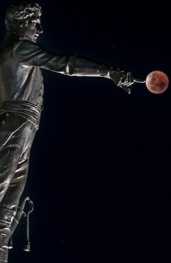 Blood Moon last night in Adelaide with the Colonel Light Statue. Picture: Steven Genesin