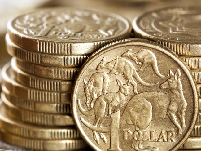 Stacks of Australian one dollar coins. Focus on front coin.