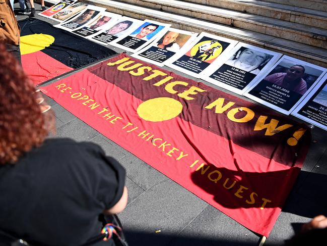 SYDNEY, AUSTRALIA - NewsWire Photos APRIL, 10, 2021: An indigenous flag in front of signs of First Nations people who have died in custody is seen during a Black Death in Custody Rally at Town Hall in Sydney. The national day of action marks 30 years since the royal commission into Aboriginal deaths in custody handed down its final report. At least 474 Aboriginal and Torres Strait Islander peoples have died in custody since then. Picture: NCA NewsWire/Bianca De Marchi