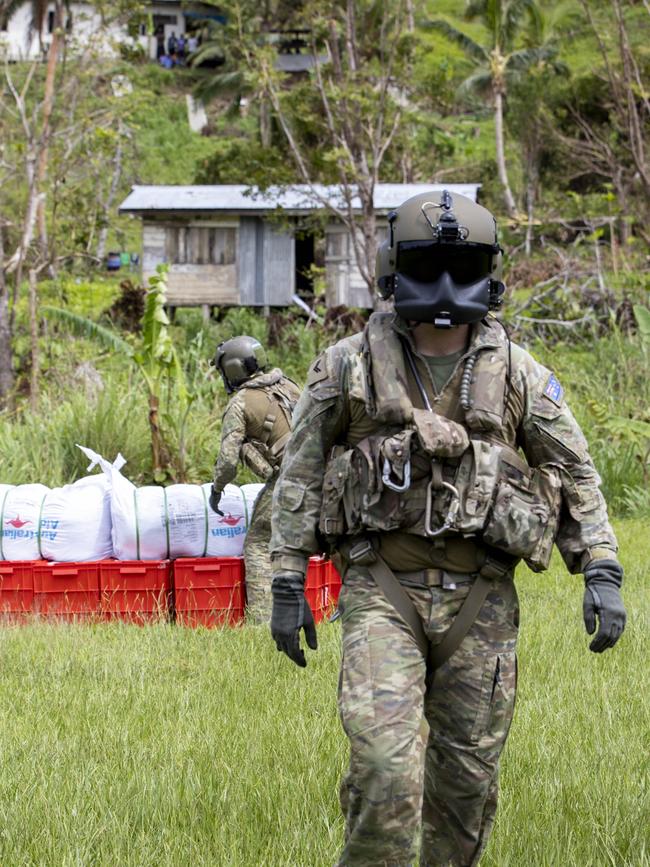 Australian Army MRH-90 Taipan crewmen unload disaster relief supplies in Nabouwalu on the island of Vanua Levu, Fiji, during Operation Fiji Assist. PICTURE: Dept of Defence.