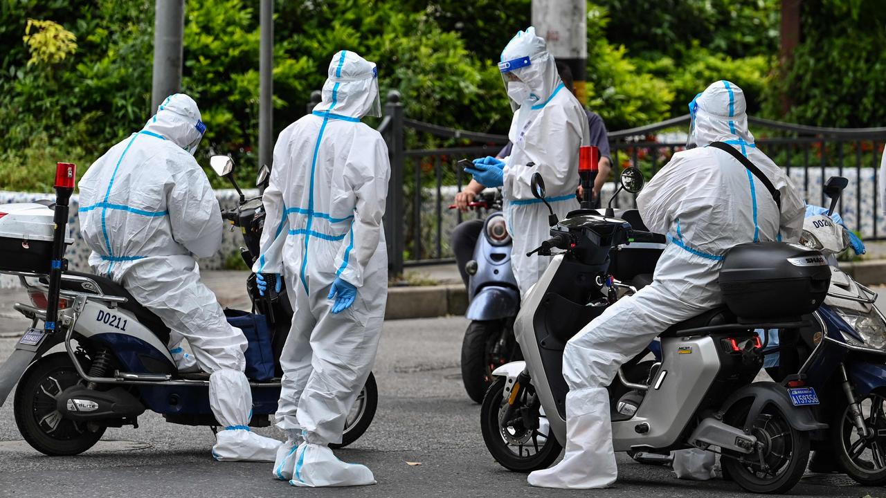 “Big whites” are what citizens have named authorities wearing white hazmat suits. Picture: Hector Retamal / AFP