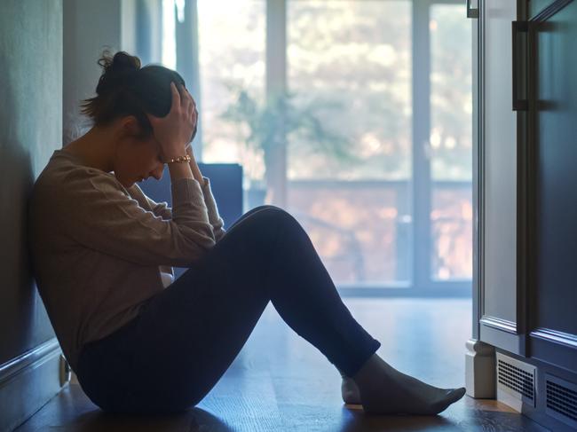 istock generic:  woman, abuse, DV, domestic violence, harassment, sexual harassment.   Sad Young Woman Sitting on the Floor In the Hallway of Her Appartment, Covering Face with Hands. Atmosphere of Depression, Trouble in Relationship, Death in the Family. Dramatic Bad News Moment . Picture: istock