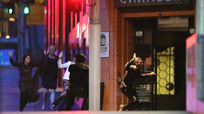 Hostages run with their hands up from the Lindt Cafe in Martin Place on the day of the siege. Picture: Joosep Martinson/Getty Images