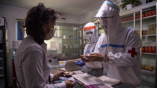 A doctor from the Korean People’s Army, right, dispenses medicine during the lockdown in Pyongyang. Picture: AFP.