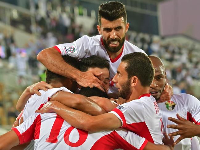 Jordan's players celebrate their opening goal during the 2019 AFC Asian Cup group B football match between Jordan and Syria at the Khalifa bin Zayed stadium in al-Ain on January 10, 2019. (Photo by Giuseppe CACACE / AFP)