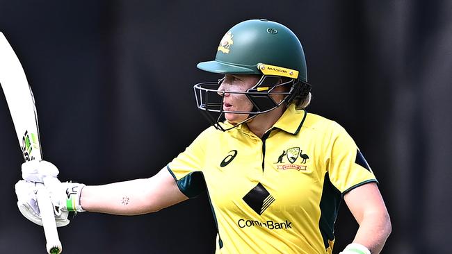 Alyssa Healy raises her bat to celebrate completing her half-century. Photo: by Ayush Kumar/Getty Images.