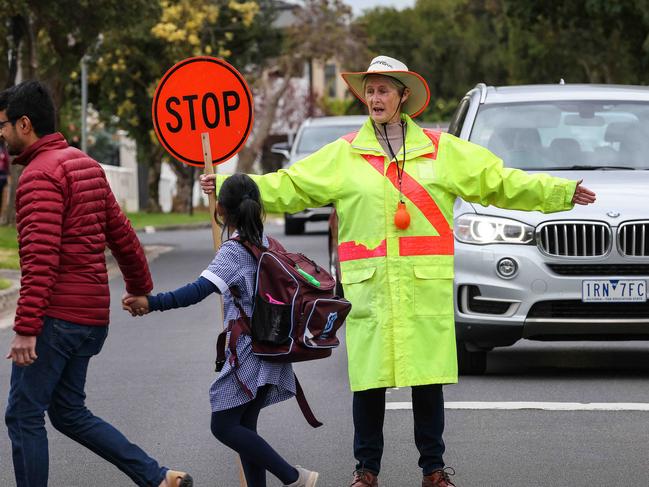 School Crossing Supervisor Fiona Woolger at work outside Mount Waverley Primary School.Some councils say they will not be able to maintain school crossing guards unless the state government continues to pay the other 50 per cent under a 1975 agreement. Picture: Ian Currie