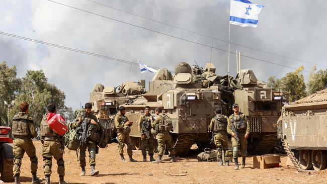 Israeli troops prepare weapons and armed vehicles near the southern city of Ashkelon.