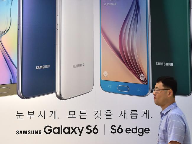 A man walks past a billboard showing the Samsung Galaxy S6 and S6 edge smartphones at the company's showroom in Seoul on July 30, 2015. South Korean giant Samsung Electronics posted an 8.0 percent fall in second quarter net profit on less than stellar sales of its flagship smartphone and stiff competition from cheaper Chinese rivals. AFP PHOTO / JUNG YEON-JE