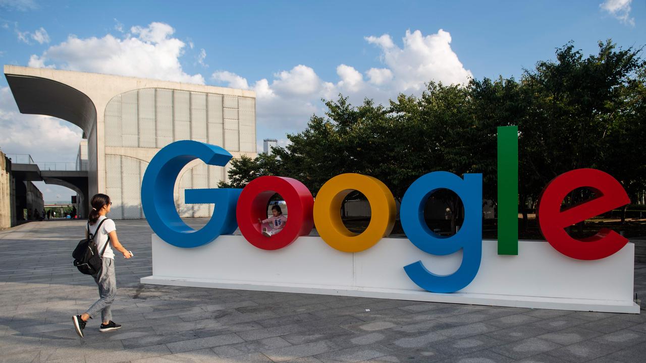 A woman and her child play on a Google sign in Shanghai. Picture: Johannes Eisele/ AFP