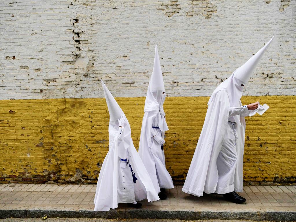 Penitents of the La Paz brotherhood arrive to take part in the Palm Sunday procession in Seville, Spain. Picture: Cristina Quicler/AFP