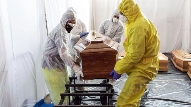 Civil Protection members and Italian paramilitary police officers move the coffin of a coronavirus victim in the village of Ponte San Pietro near Bergamo, Italy. Picture: Marco Di Lauro/Getty Images