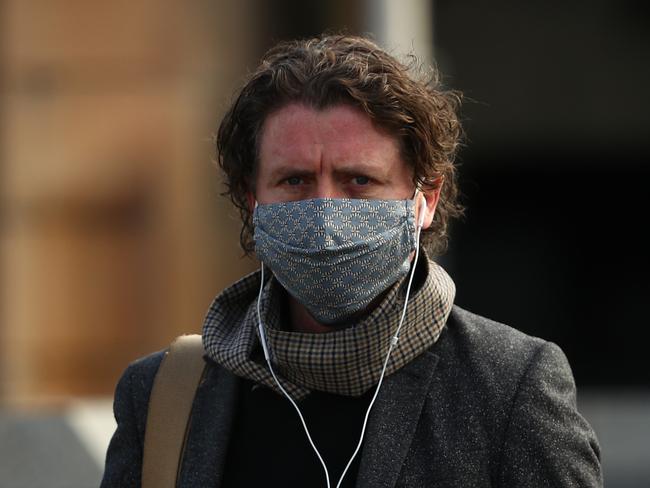 MELBOURNE, AUSTRALIA - JULY 23:  A man walks along Princes Bridge on July 23, 2020 in Melbourne, Australia. Face masks or face coverings are now mandatory for anyone leaving their homes in the Melbourne metropolitan area or the Mitchell Shire. Under the new rule, which came into effect at midnight on Thursday, anyone failing to wear a mask in public can receive a $200 fine. Metropolitan Melbourne and the Mitchell shire remain in lockdown due to the rise in COVID-19 cases through community transmissions, with residents in lockdown areas under stay at home orders until 19 August. People are only able to leave home have for exercise or work, to buy essential items including food or to access childcare and healthcare. (Photo by Robert Cianflone/Getty Images)