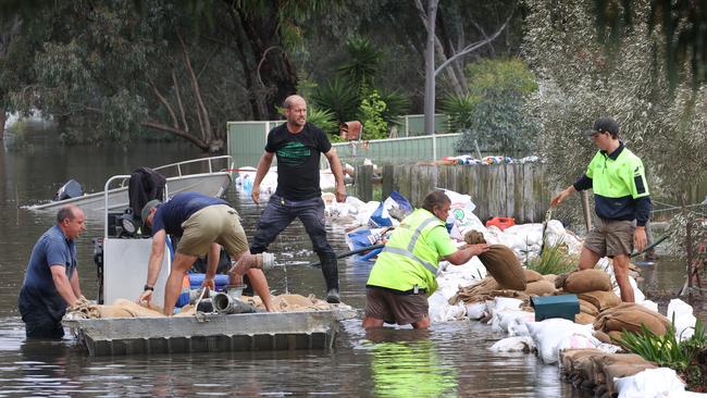 Community volunteers transport Sandbags by boat to shore up walls. Picture: David Caird