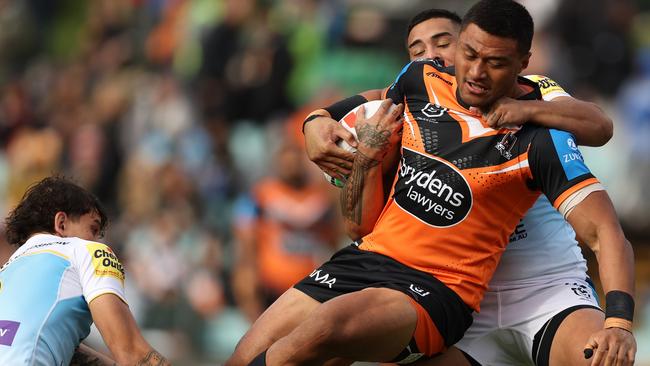 SYDNEY, AUSTRALIA - JUNE 15: Stefano Utoikamanu of the Wests Tigers is tackled during the round 15 NRL match between Wests Tigers and Gold Coast Titans at Leichhardt Oval on June 15, 2024 in Sydney, Australia. (Photo by Jason McCawley/Getty Images)