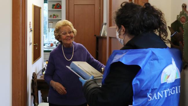 A volunteer visits a frail elderly woman in Rome, Italy, during the coronavirus lock down. Picture: Marco Di Lauro/Getty Images