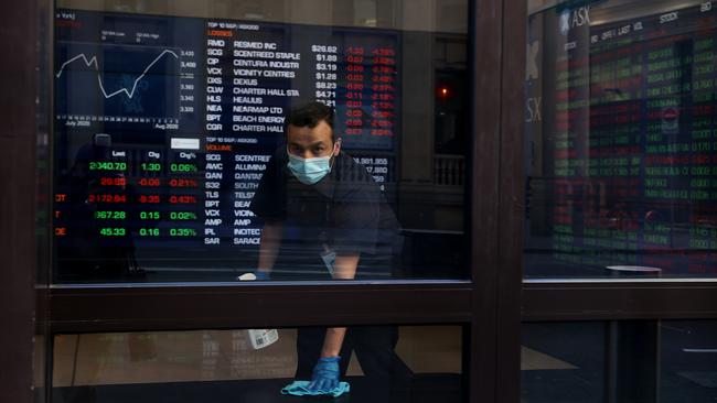 A man sanitises the benches at ASX in Sydney. Picture: Dylan Coker