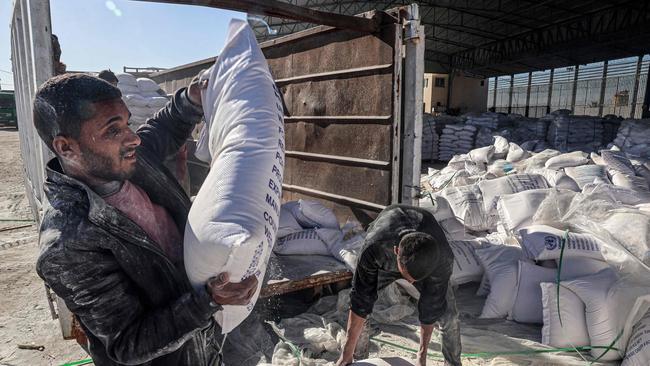 Workers unload bags of humanitarian aid. Picture: Said Khatib / AFP