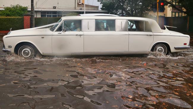 A limo gets caught in heavy flooding on the corner of St Kilda and Grosvenor streets in Brighton. Picture: Hamish Blair