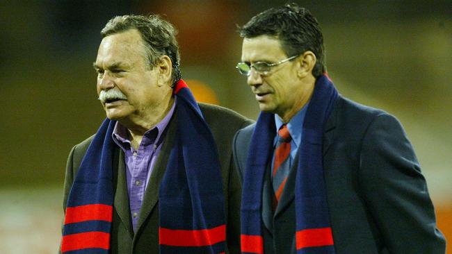 Ron Barassi and Robert Flower walk onto the MCG.