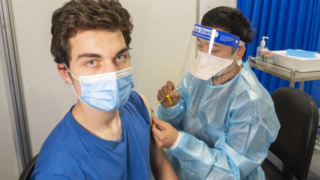 Alex Barlow, 18, gets vaccinated by Raymond Rodondo at the Exhibition Centre. Picture: Rob Leeson.