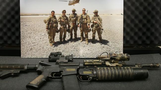 Leading from the front, at his own risk ... Cameron with his team in southern Afghanistan; and the M4 rifle he carried on his final mission, at the Australian War Memorial.