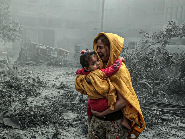 GAZA CITY, GAZA - OCTOBER 23: A woman holding a girl reacts after Israeli airstrikes hit Ridwan neighborhood of Gaza City, Gaza on October 23, 2023. (Photo by Ali Jadallah/Anadolu via Getty Images)