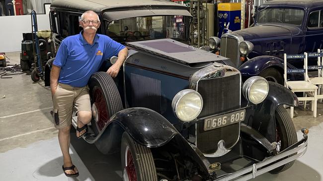 Owner Mike Munday of Roadside Relics with a black 1930 Graham Paige and a blue 1933 Chevrolet.