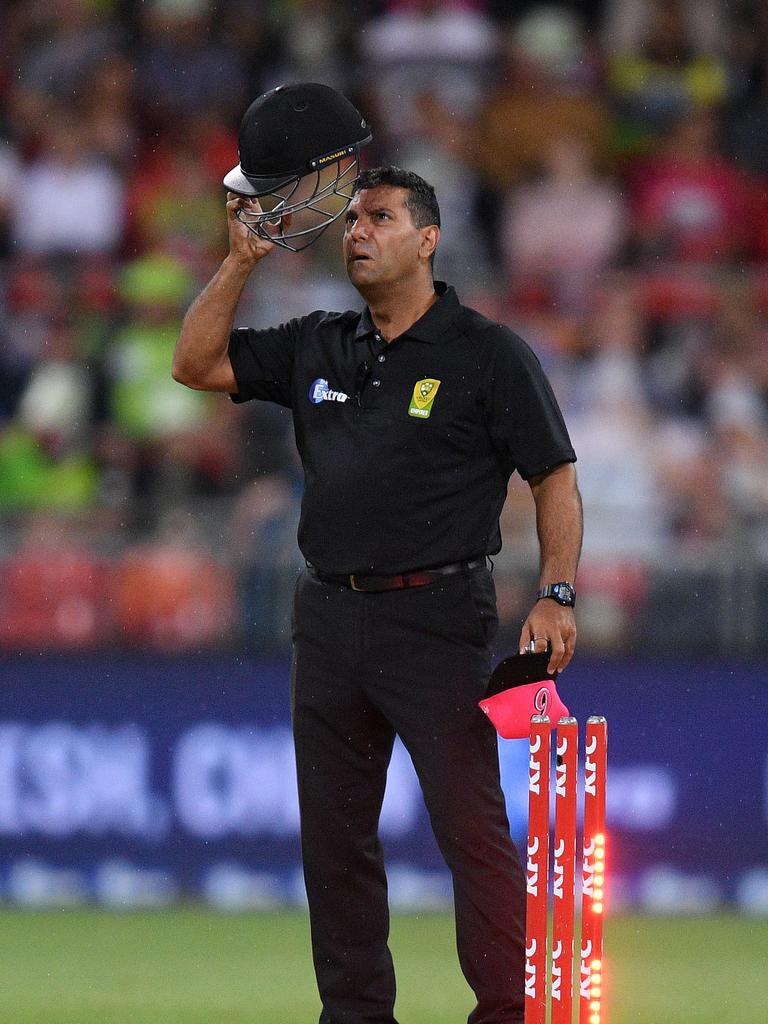 Umpire Gerard Abood wears a helmet during games. (AAP Image/Dan Himbrechts)