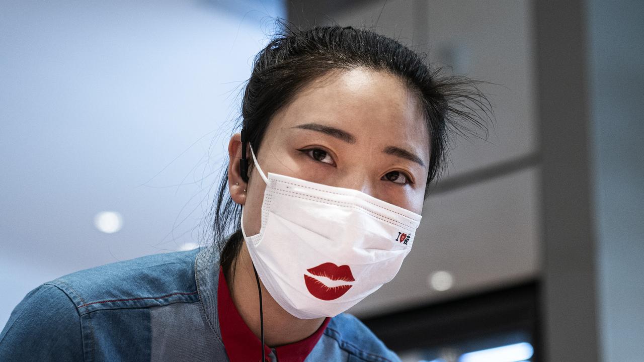 A waitress is pictured wearing a face mask while serving guests in Wuhan, more than a year after coronavirus emerged. Picture: Getty Images