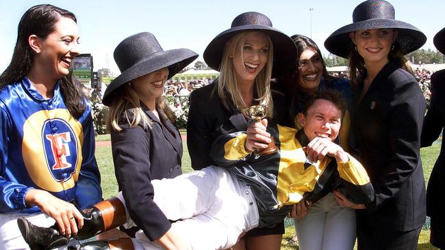 Chris Munce poses for photographers with promotional girls after winning the the Melbourne Cup on Jezabeel. Picture: AFP